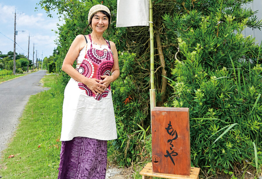 敷地入口にて、林さんと映画館もりのこやの木の看板